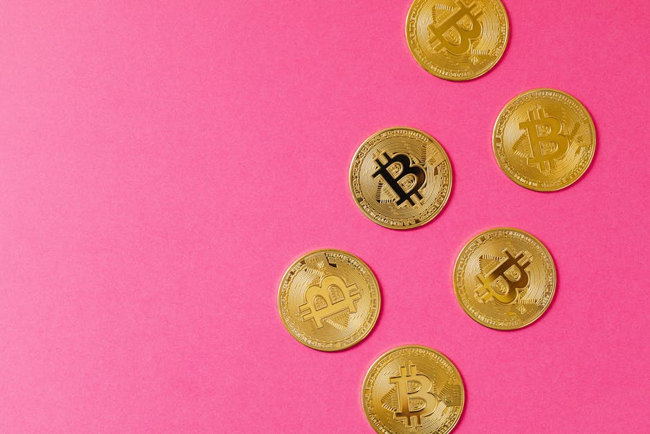 Gold Bitcoin coins on a vibrant pink surface